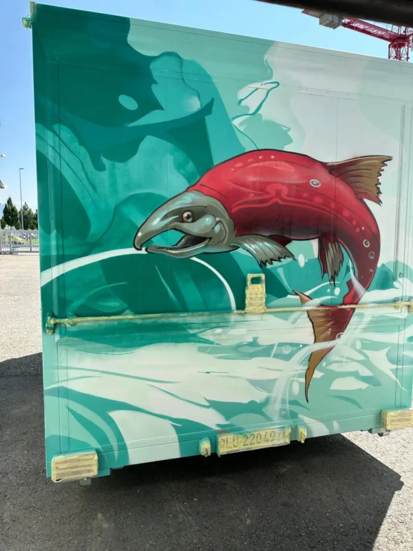 Graffiti-Detail: roter Lachs auf türkisem Wasser